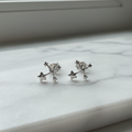 Small silver star cluster constellation stud earrings on white marble