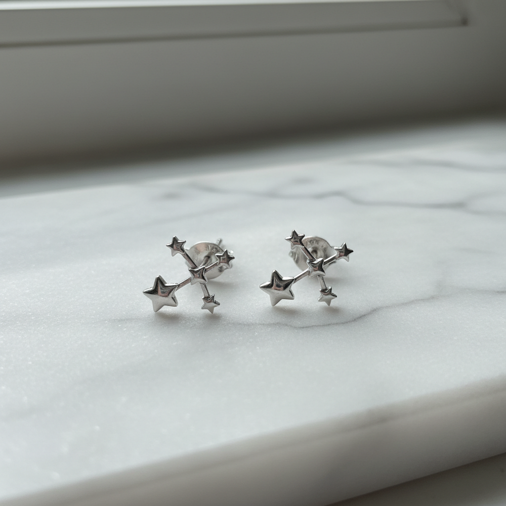 Small silver star cluster constellation stud earrings on white marble